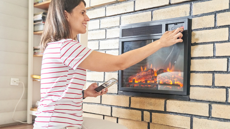 Woman turning on furnace in her home