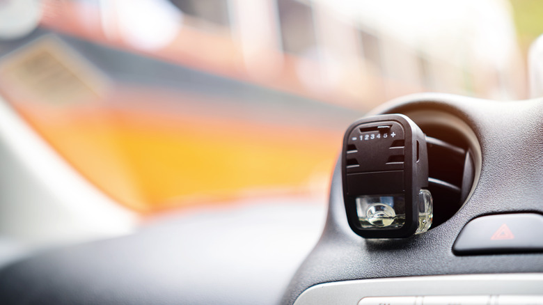 A vehicle air freshener attached to a vent.