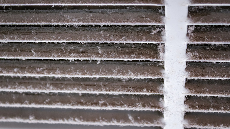 An air vent grille covered in dust.