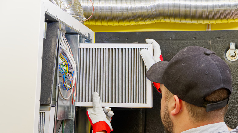An HVAC technician changing a dirty air filter.