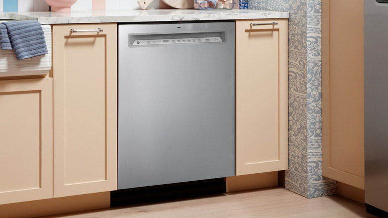 A GE brand dishwasher in a mostly wood kitchen.