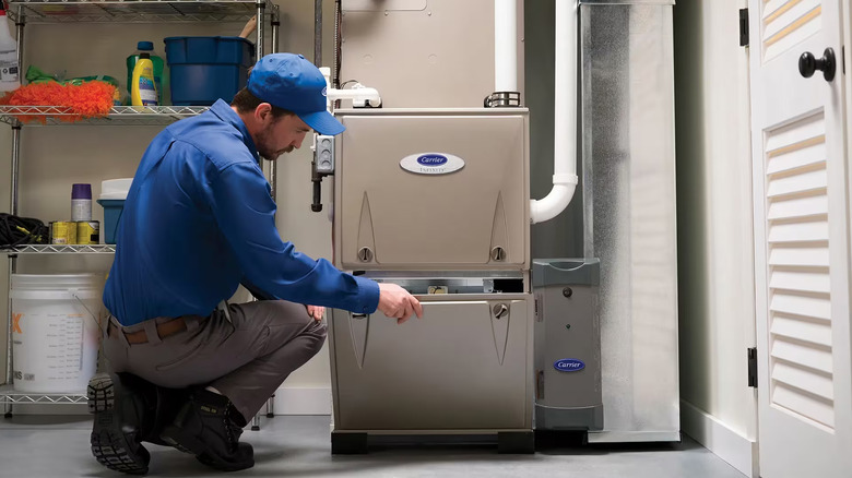 A technician working on a Carrier-brand furnace