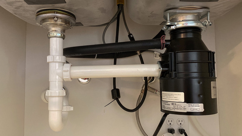 An under-sink garbage disposal setup.