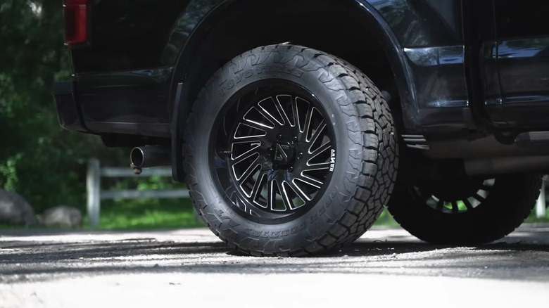 The rear wheel of a Ford F-150 with Toyo Open Country AT3 tires and aftermarket wheels