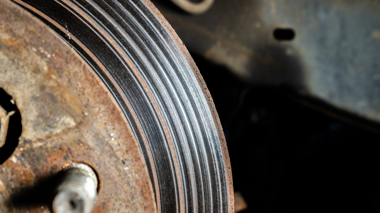 Car brake rotor with visible grooves and damage