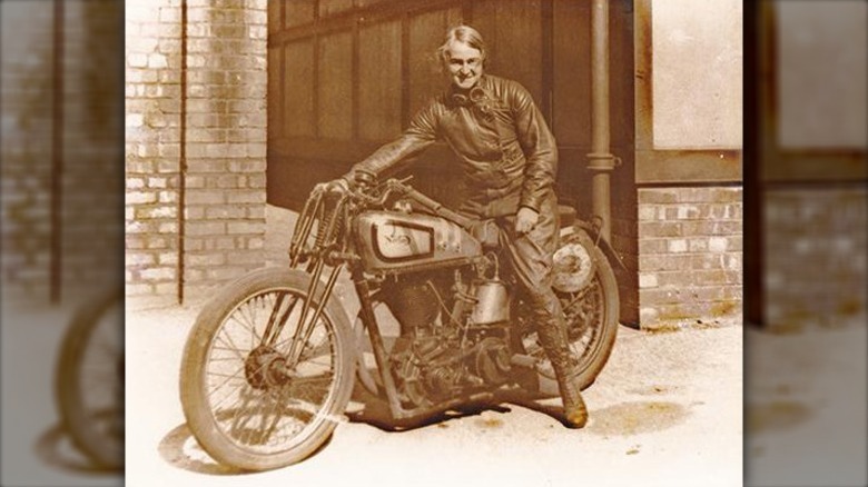 Beatrice Shilling on a Norton motorcycle in front of a building