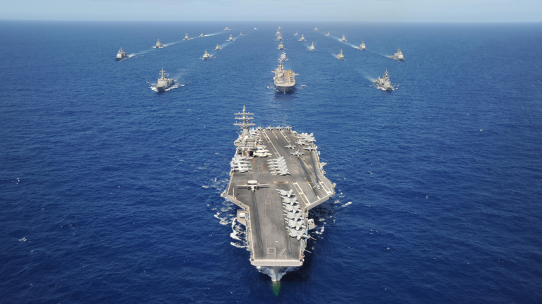 Aircraft carrier strike group sailing in formation with a carrier leading the way
