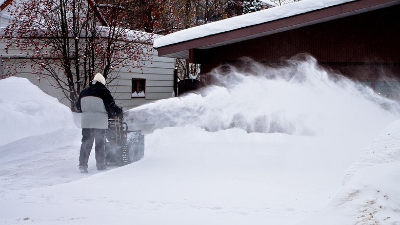 Man blowing snow off driveway with Honda snowblower