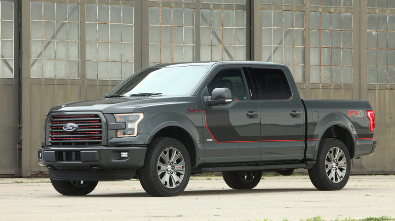 2015 Ford F-150 parked in industrial setting, front-left 3/4 view