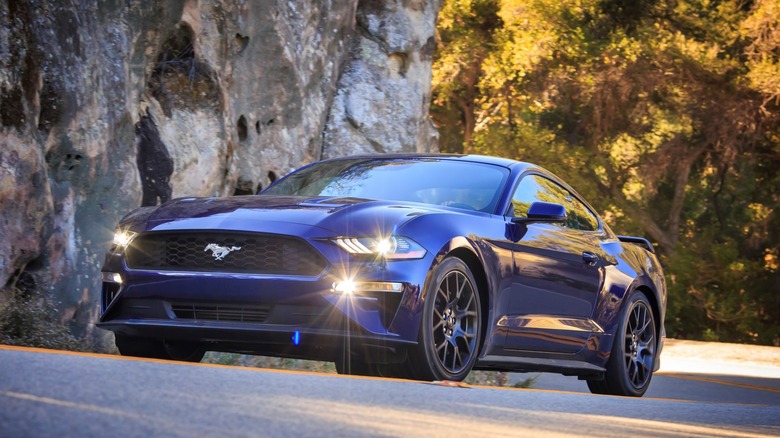2018 Ford Mustang GT driving slowly, front-left 3/4 view, dark blue exterior