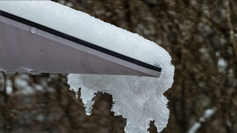 A Starlink dish covered in snow being melted.