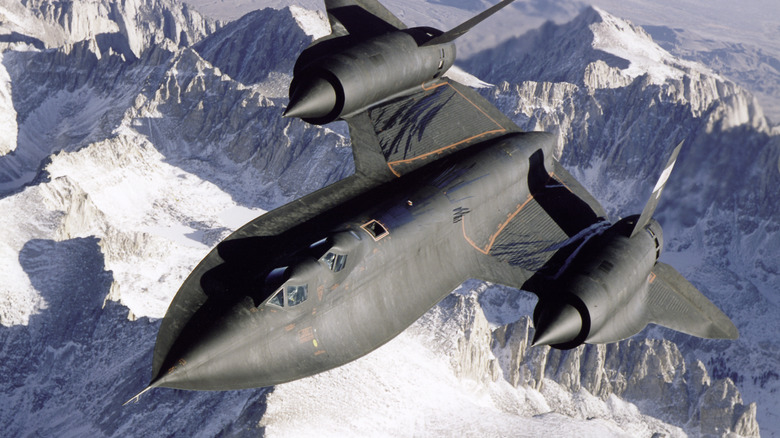 A SR-71 Blackbird flies over snow-capped mountains, USA, 1995