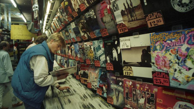 A young man looking through used vinyl record collection in record store