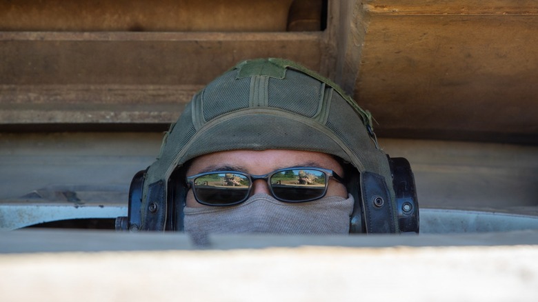A driver of a U.S. Army M1 Abrams tank peeking through the hatch during gunnery training