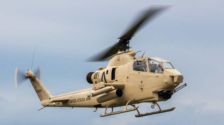 Sandy brown Cobra helicopter in flight