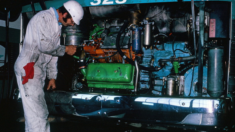 Technician servicing a Detroit 71-series diesel engine in an AC Transit GM New Look bus