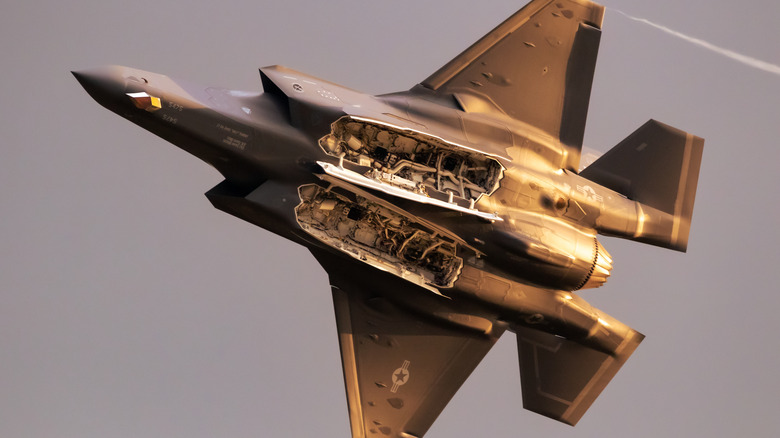 An F-35 with flying with open bomb bays