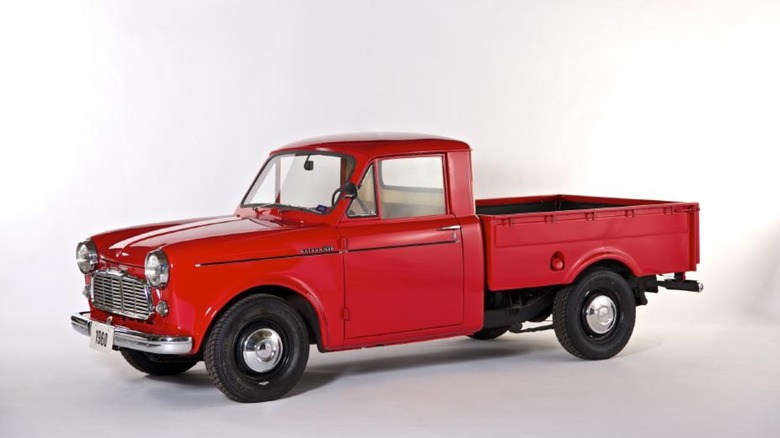 A red Nissan Datsun pickup truck against a white background