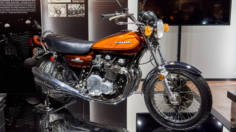 A Kawasaki Z1 on a display stand in a museum-like setting.