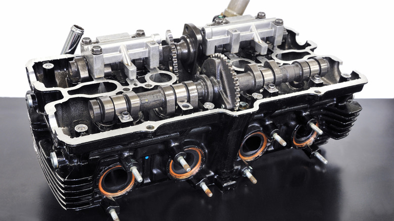 Image shows an in-line, twin-cam, four-cylinder motorcycle head with valve covers removed.