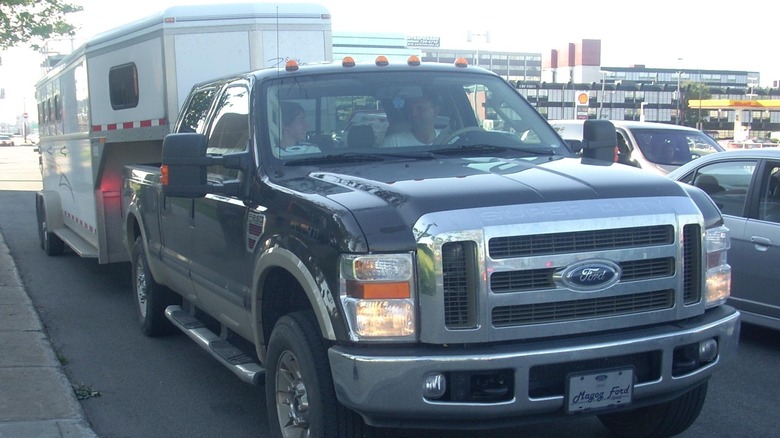 Two friends riding in a 2008 Ford Super Duty hauling a camper