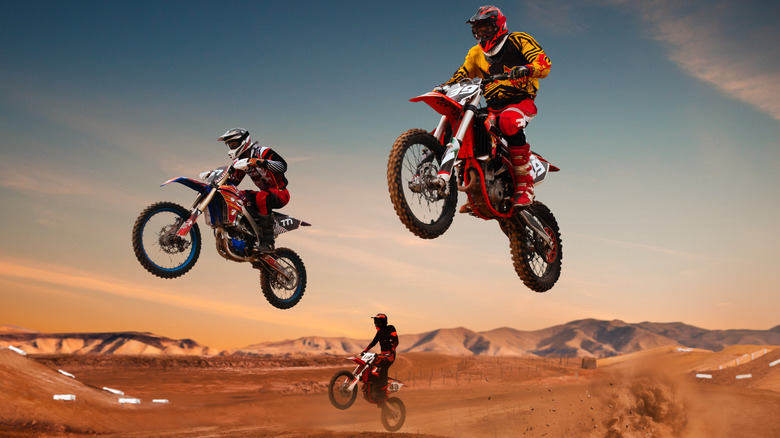 three racers jumping motocross