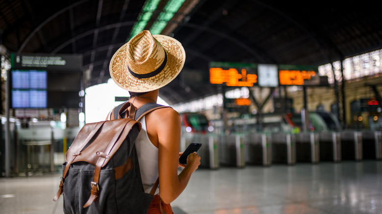 Woman in train station holding phone