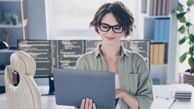 person with glasses looking at laptop