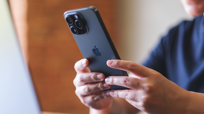 person holding an iPhone and typing