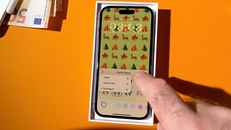 person adjusting iPhone screen with Arabic font