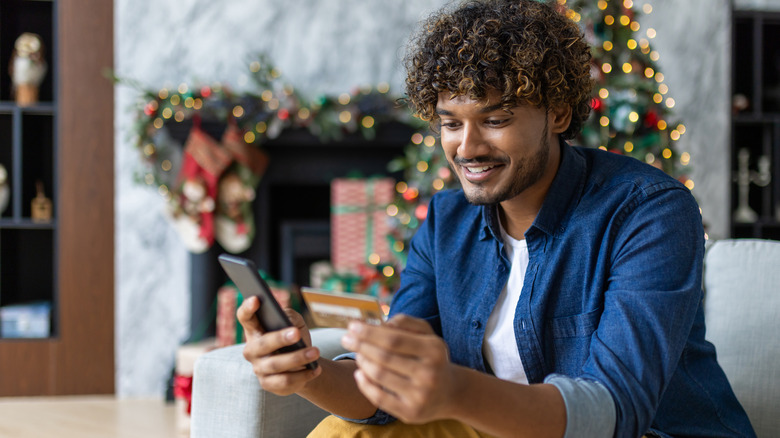 man holding phone credit card