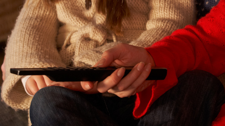 person using TV remote