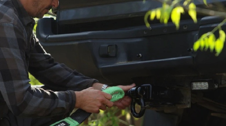 Attaching a tow strap to a hitch receiver shackle.