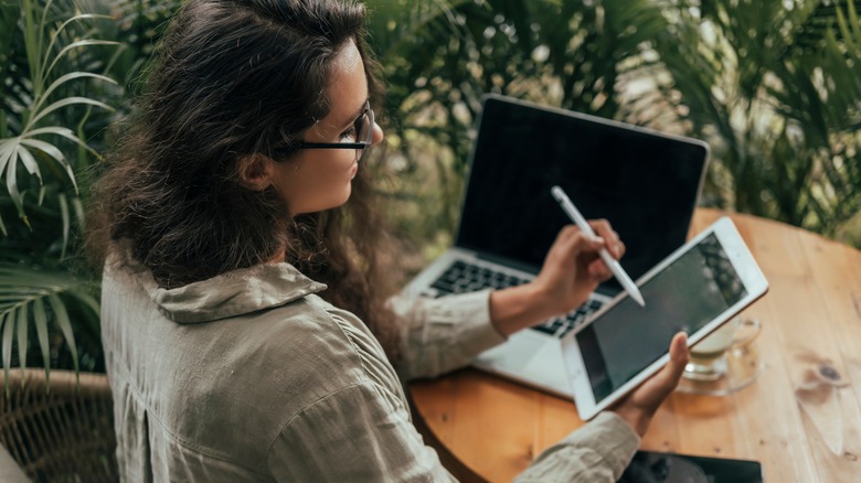 a woman holding an iPad with Apple Pencil