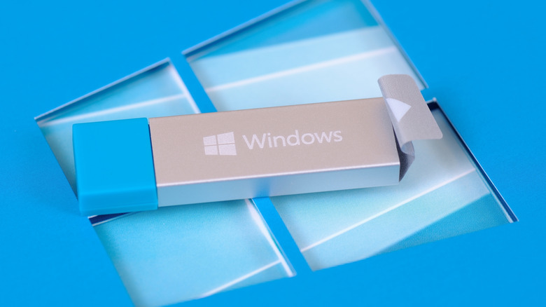 A silver USB drive with Windows logo on it