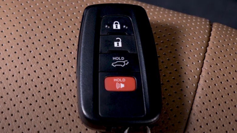 A Toyota key fob on a brown seat cushion.