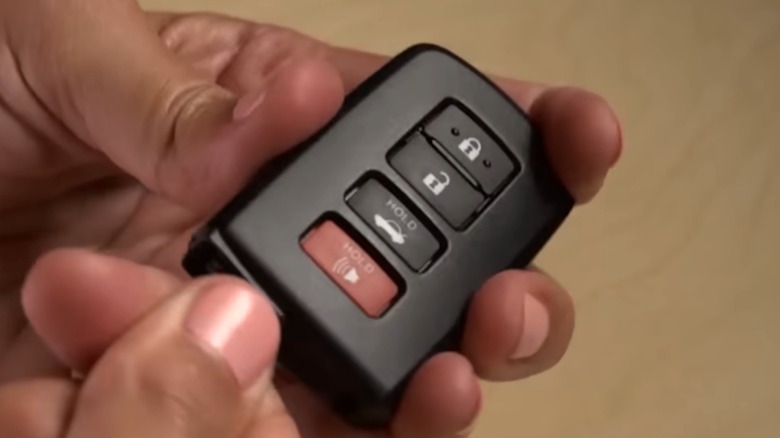 Two hands preparing to open a Toyota key fob.
