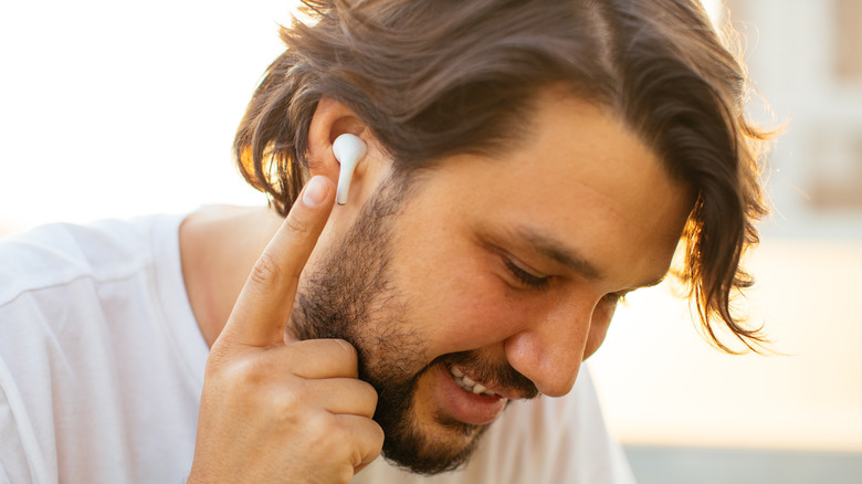 Man touching AirPod