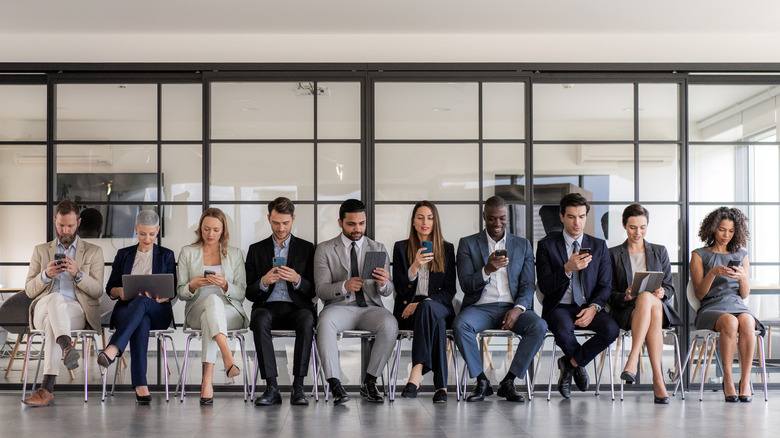 group of people using phone while in line