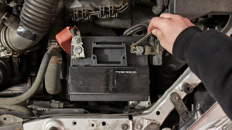 Person disconnects car battery terminals