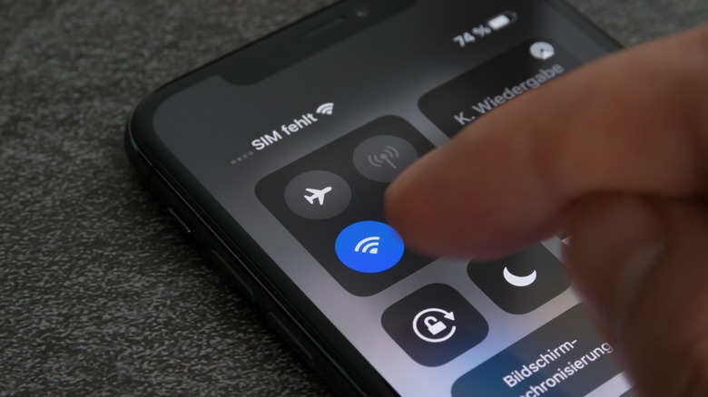 finger hovers over Wi-Fi button iPhone