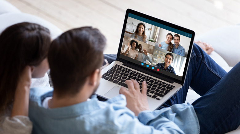 Two people use video conferencing software on laptop