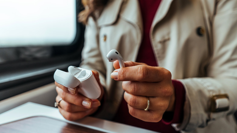 woman holding AirPods in hands