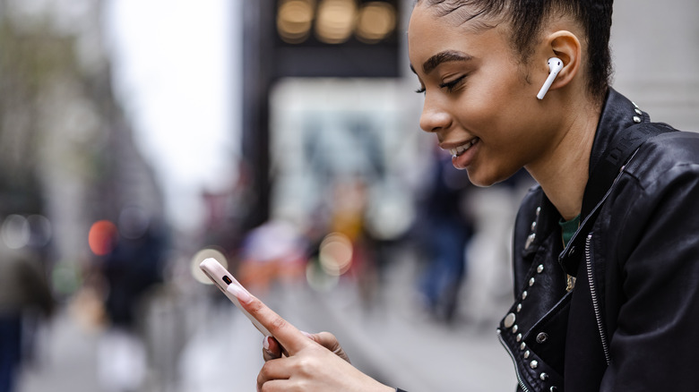 woman using airpods and smiling