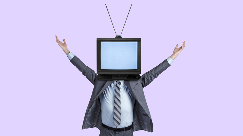 Person in business suit with arms raised, with analog TV and antennae over their head