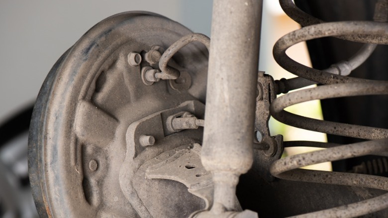 A closeup image of a drum brake system showing the inspection port on the upper right side of the backing plate