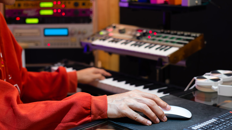 music producer uses a keyboard in studio
