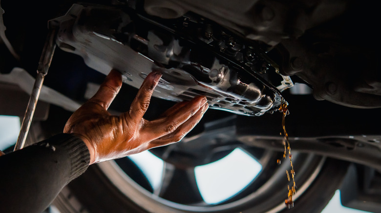 Mechanic draining the old ATF from an autommatic vehicle