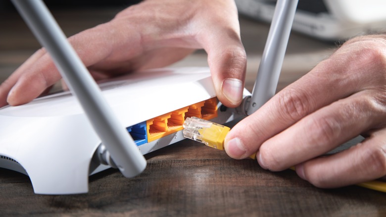 plugging Ethernet cable into router.