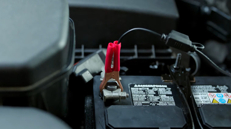 Close up of a car battery hooked on a red clipped connector